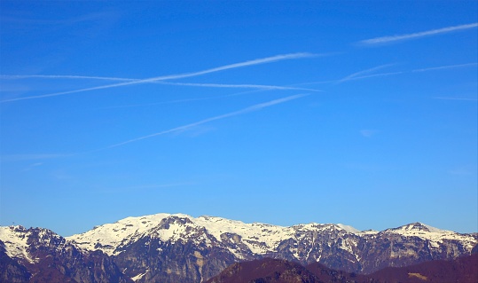 mountain panorama with many white chemtrails left by the Arians or by something else According to the conspiracy theory
