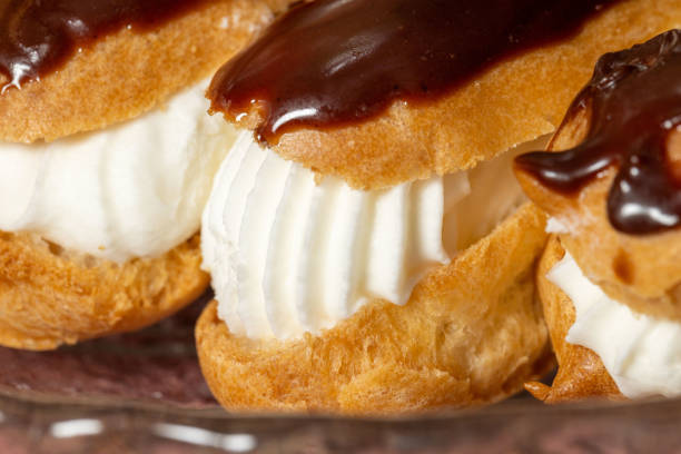 istock Delicious eclairs filled with fresh cream and topped with chocolate icing 2151016294