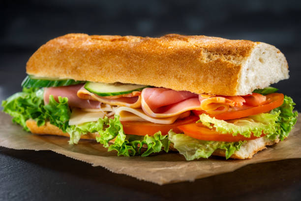 istock Big sandwich with ham on dark background 2151016539