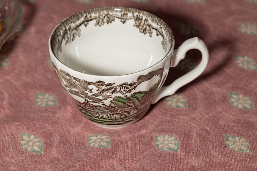 Porcelain cup from England with a village pattern - on a tablecloth