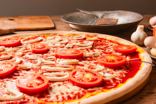 Italian Pizza Napoletana in Messy Kitchen with Cooking Ingredients