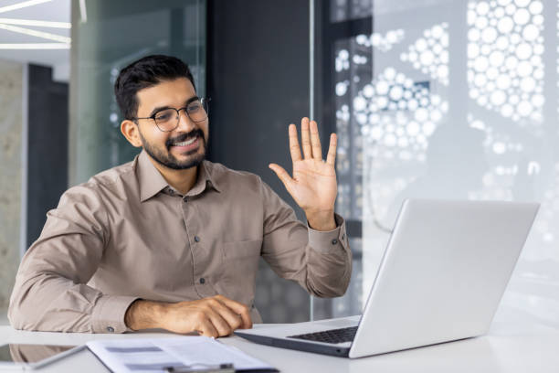 istock Smiling businessman waving during a video conference 2151019226