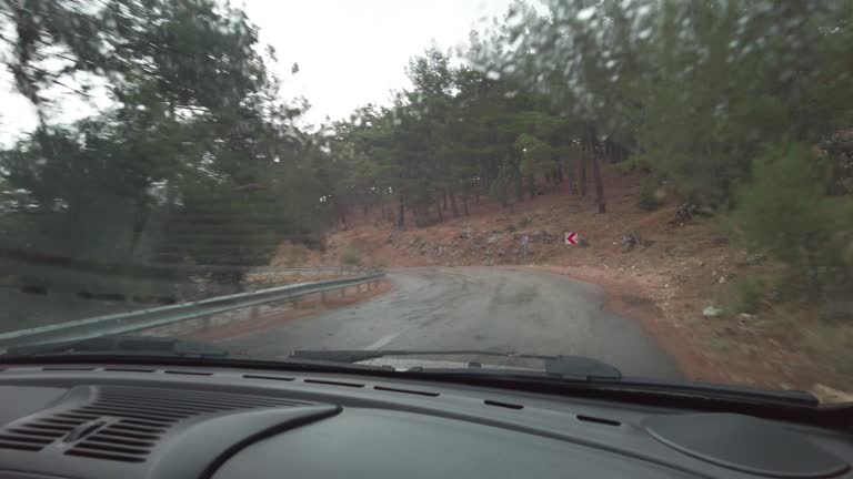 Vehicle driving on a mountain road while it is raining