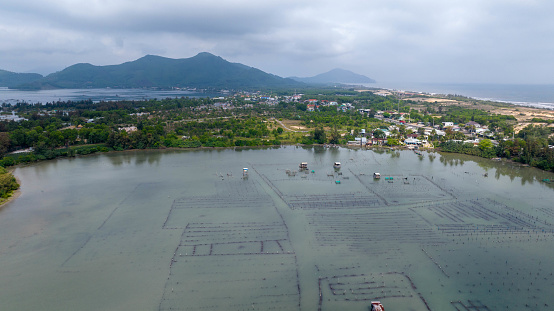 Hue, Vietnam, a barrier system (a form of aquaculture) divides the water into fields dotted with small boats and fishermen's huts