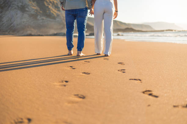 istock Unrecognizable Couple Walking Barefoot on Summer Beach, Leaving Footprints in Sand 2151023440