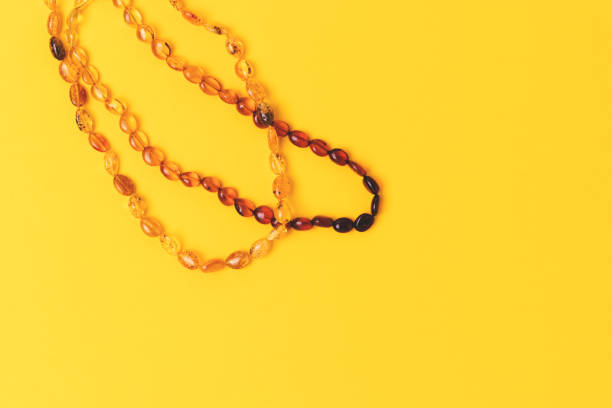 istock Amber beads laid on a yellow background. 2151024871
