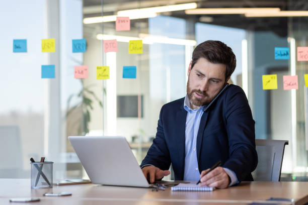 istock Businessman using phone at modern office desk 2151025169