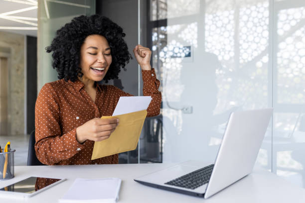 istock Successful young woman celebrating while reading a letter 2151025635