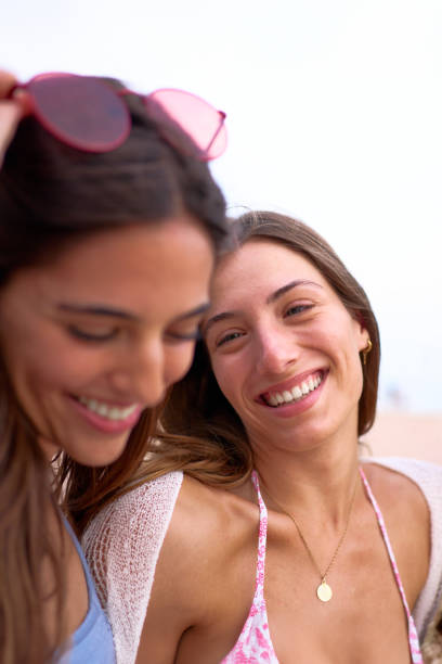 istock Three joyful European nice women laughing at beach in summer. Fe 2151025800