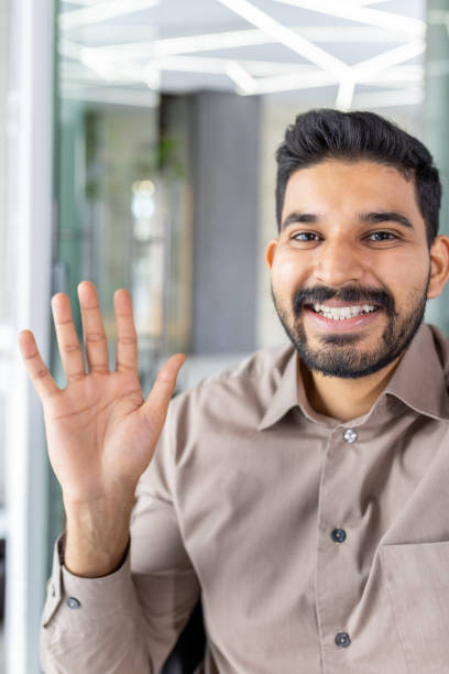 istock Businessman greeting during a video call in a modern office 2151028038