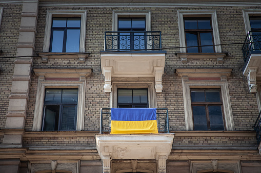 Picture of the Latvian flag waiving at a balcony in Riga, celebrating the solidarity between Latvia and Ukraine.