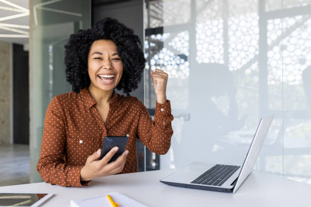 istock Young woman celebrates success at modern office 2151029819