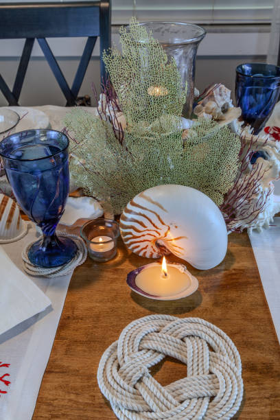 istock Seashell and candle decoration on a nautical table setting with natural colors 2151032568