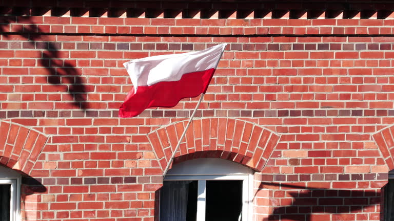 The Polish flag flying on the facade of a red brick tenement house