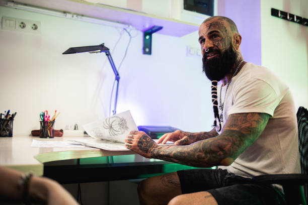istock Tattoo artist working with a client on a sketch 2151033461