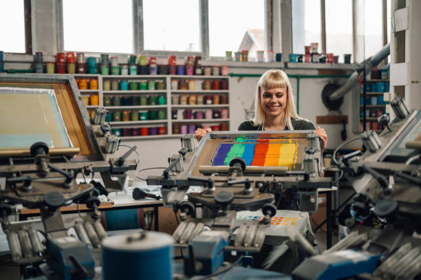 istock Print shop worker silkscreen printing at facility. 2151033677