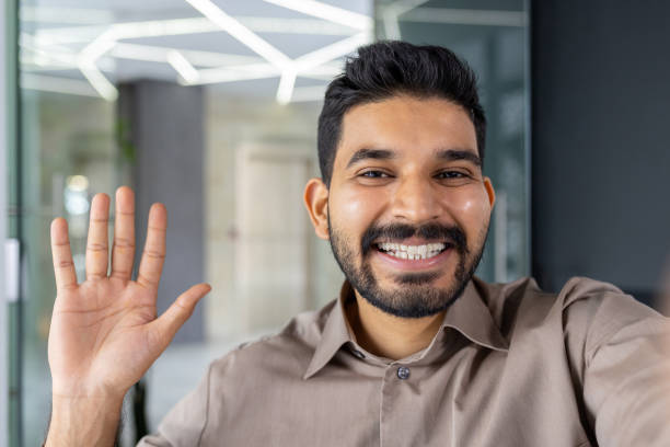 istock Businessman waving and smiling during a video call 2151034933