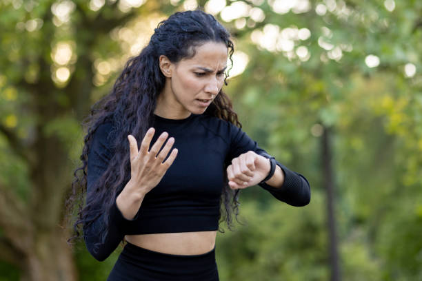 istock Confused Hispanic woman checking time during outdoor workout 2151036535