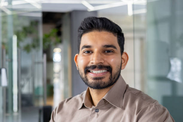 istock Confident young man smiling in a modern office environment 2151037404