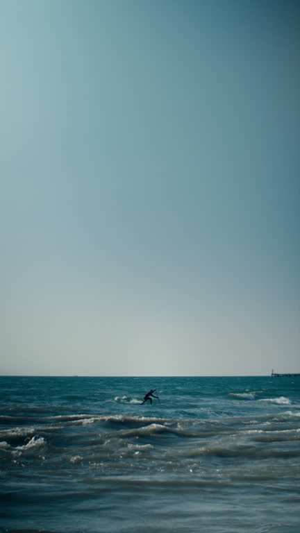Man is floating on a surfboard, rowing with an paddle. Male stands on a supboarding board, SUP