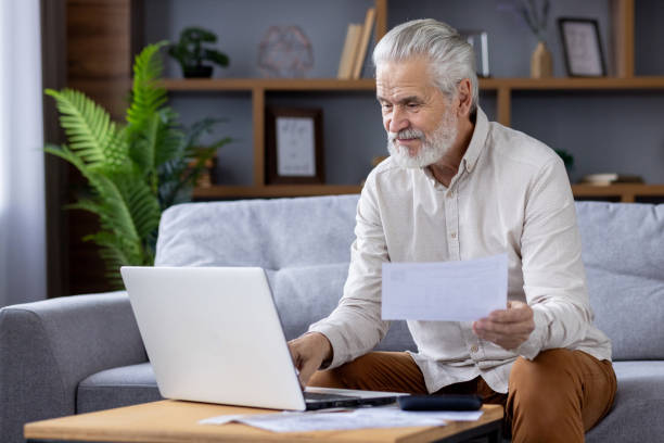 istock Senior man managing finances at home with laptop and documents 2151037605