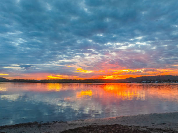 istock Sunrise over the bay water with clouds and reflections 2151038167
