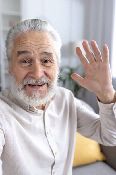 istock Smiling senior man greeting with a wave in a home setting 2151038206