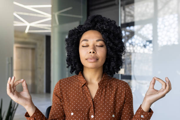 istock Young woman meditating peacefully in a modern office 2151038262