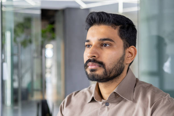 istock Young professional man pensively looking away in office 2151039114