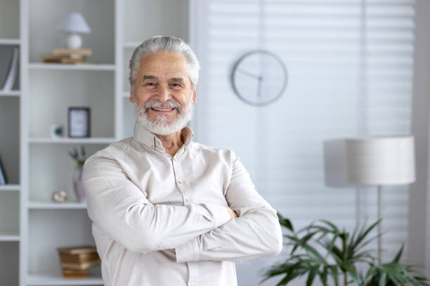 istock Confident senior man smiling in a modern home interior 2151039990