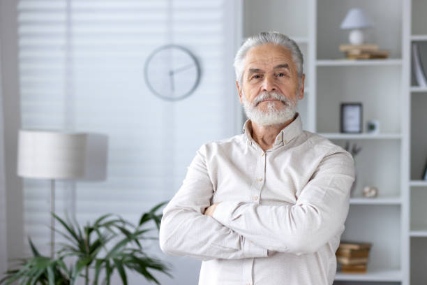 istock Confident senior man standing in a modern home 2151040256
