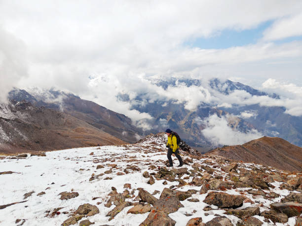 istock Snow-dusted mountain ridge with rugged terrain under a cloudy sky 2151040922