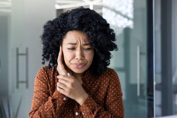 istock Young woman feeling severe ear pain in a modern office 2151041465