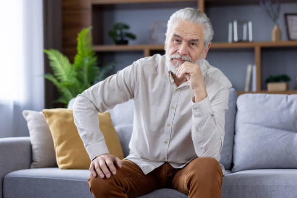 istock Thoughtful senior man sitting relaxed on his couch at home 2151043577
