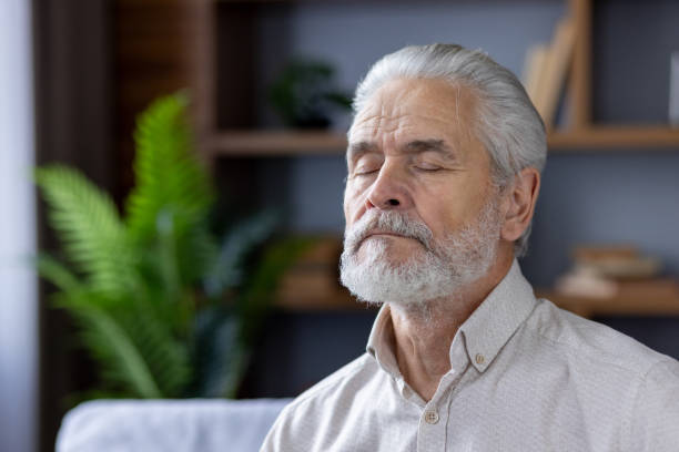 istock Senior man meditating peacefully in a modern home 2151043999