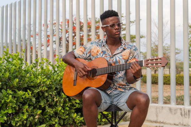 istock Musician Strumming Guitar in Tranquil Outdoor Environment 2151044443
