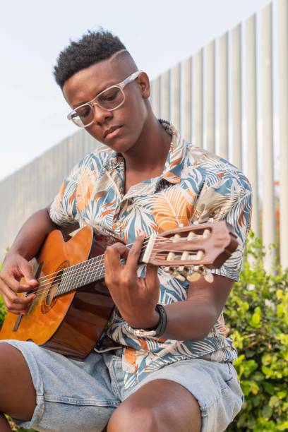 istock Close-up of Young Man Focused on Playing Guitar 2151044449