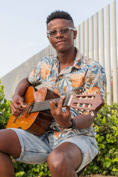 istock Smiling Young Musician with Guitar in Outdoor Setting 2151044533