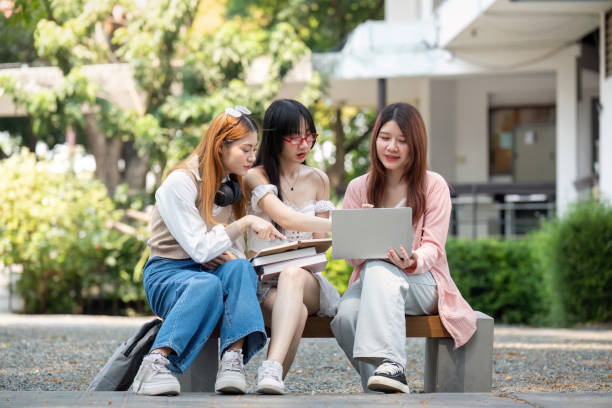 istock Asian young campus student enjoy learn study and reading books together. Friendship and Education concept. Campus school and university. Happiness and funny of learning in college 2151044764