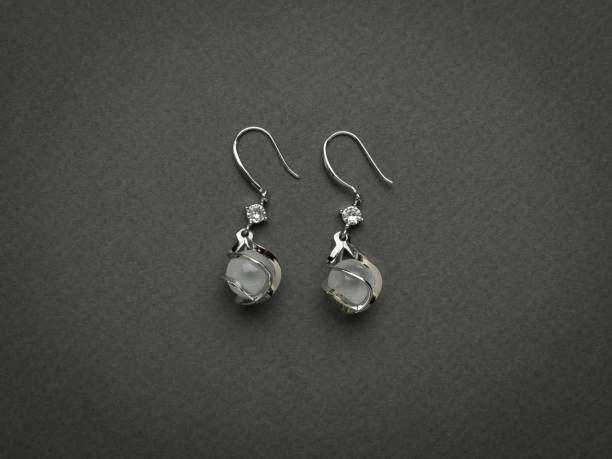 istock Two women's earrings with a stone on a gray background. 2151044800