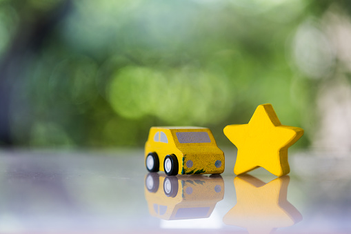 Wood car and wood star for scoring satisfaction surveys, the best service warranty concept.