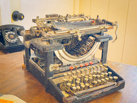 An antique typewriter sitting on a desk