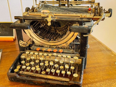 An antique typewriter sitting on a desk