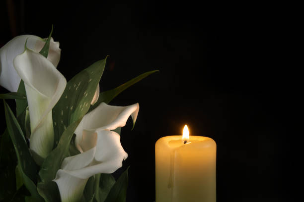 istock Burning wax candle in close up and white calla lily 2151047563