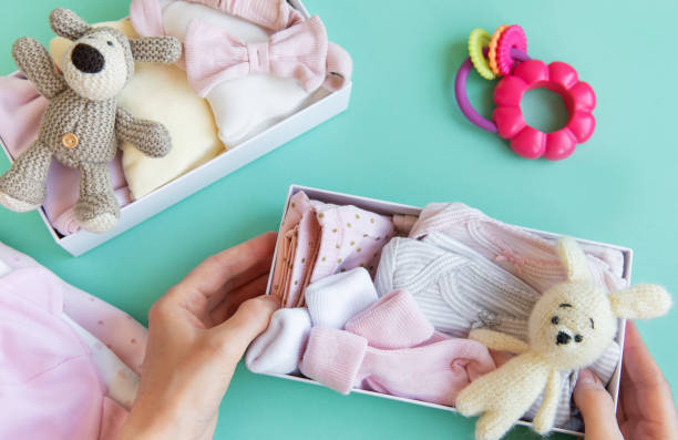 istock Women's hands collect children's clothes into boxes. 2151050959