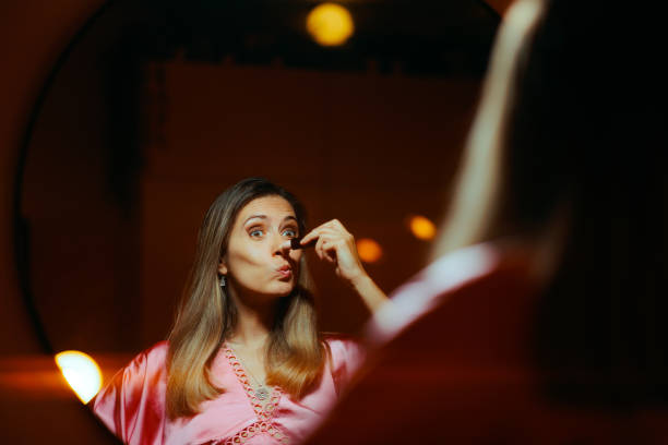 Three Actresses in period costumes in dressing room. Getting ready for stage performance. Last minute adjusting of make up, and hair. Interior of dressing room  of Theatre building at night.