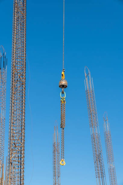 Transporting portable toilet for construction site of skyscraper by tower crane, background with copy space