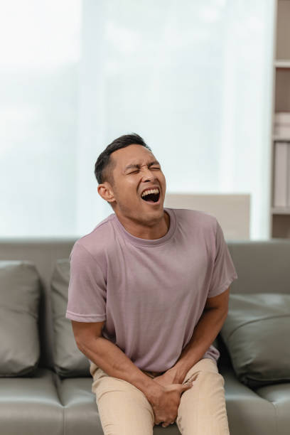 istock A man is sitting on a sofa and touching his crotch. The concept of holding back pee, missing the bathroom, prostate cancer, UTI or urinary tract infection. 2151061209