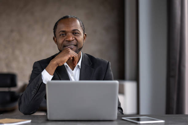 istock Confident businessman smiling at workspace with laptop 2151062442