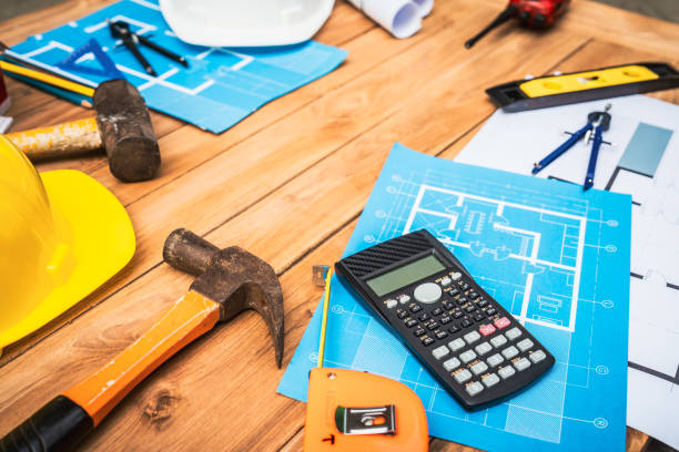 istock Top view desk of Engineer tools meticulously designs structures at desk, referring to blueprints for precision. Focuses on innovation, problem-solving, and attention to detail in engineering projects 2151063657